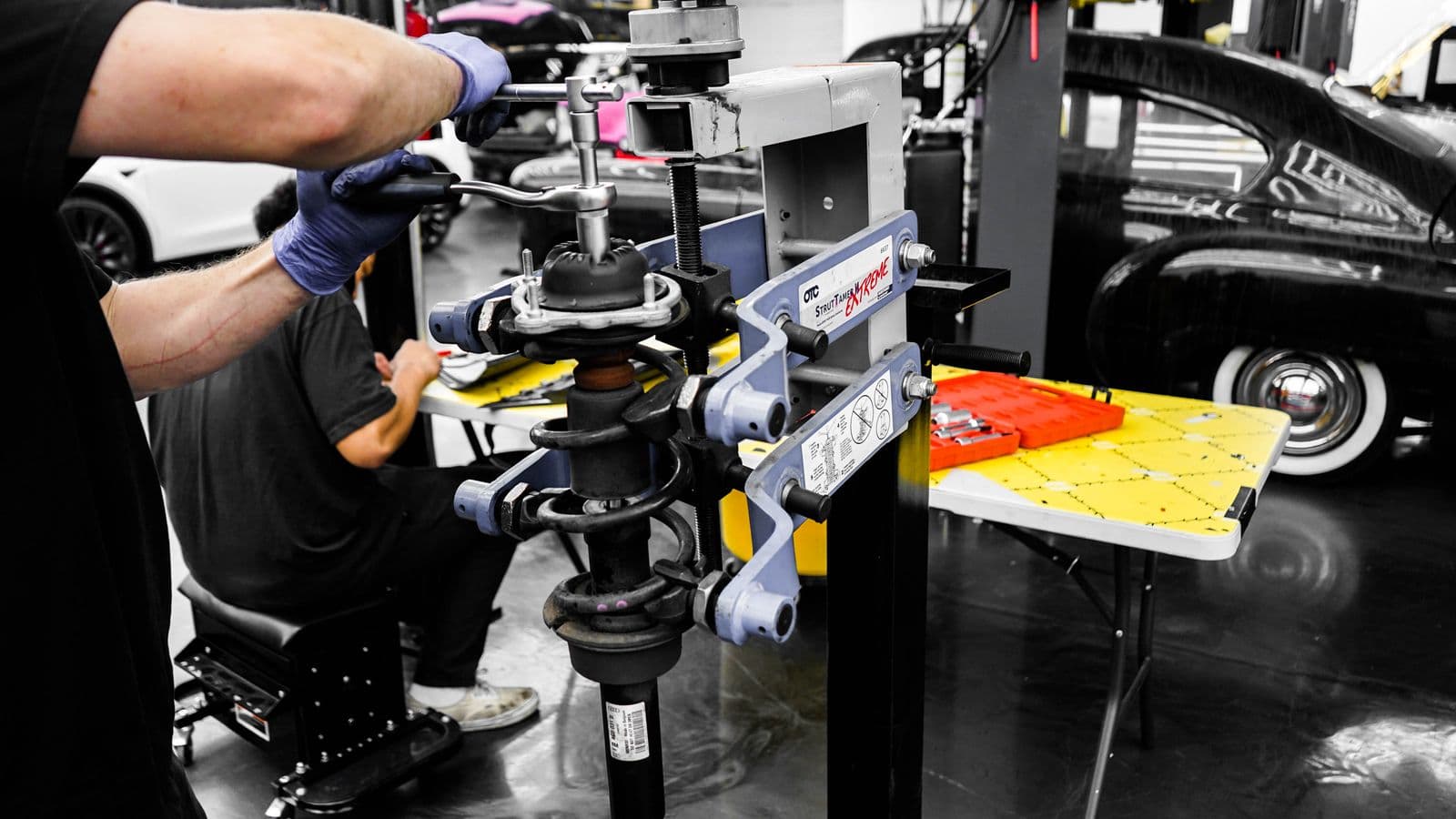 Profissional trabalhando com ferramentas em uma oficina automotiva